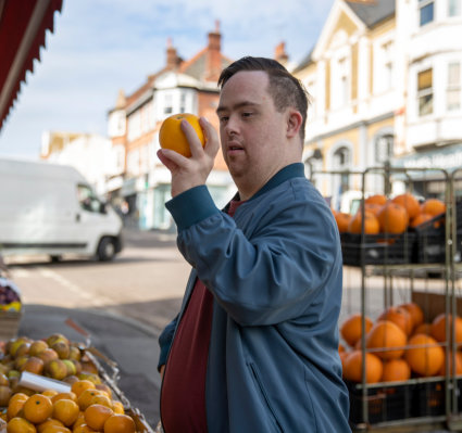 boy picking up orange