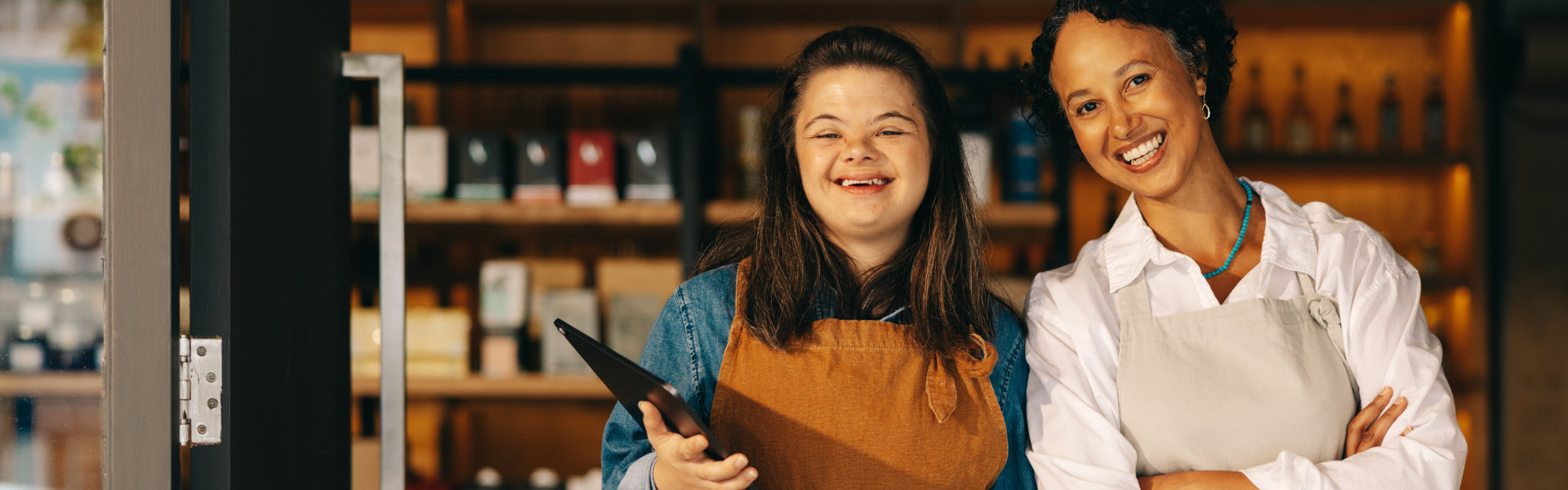 Two successful shop employees smiling at the camera happily